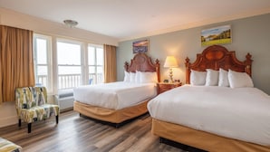Habitación de hotel con dos camas, una silla, una lámpara y un cuadro en la pared.