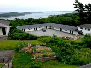 A building with a parking lot and a view of the sea. - Wonder View Inn - Bar Harbor Collection (Bar Harbor)