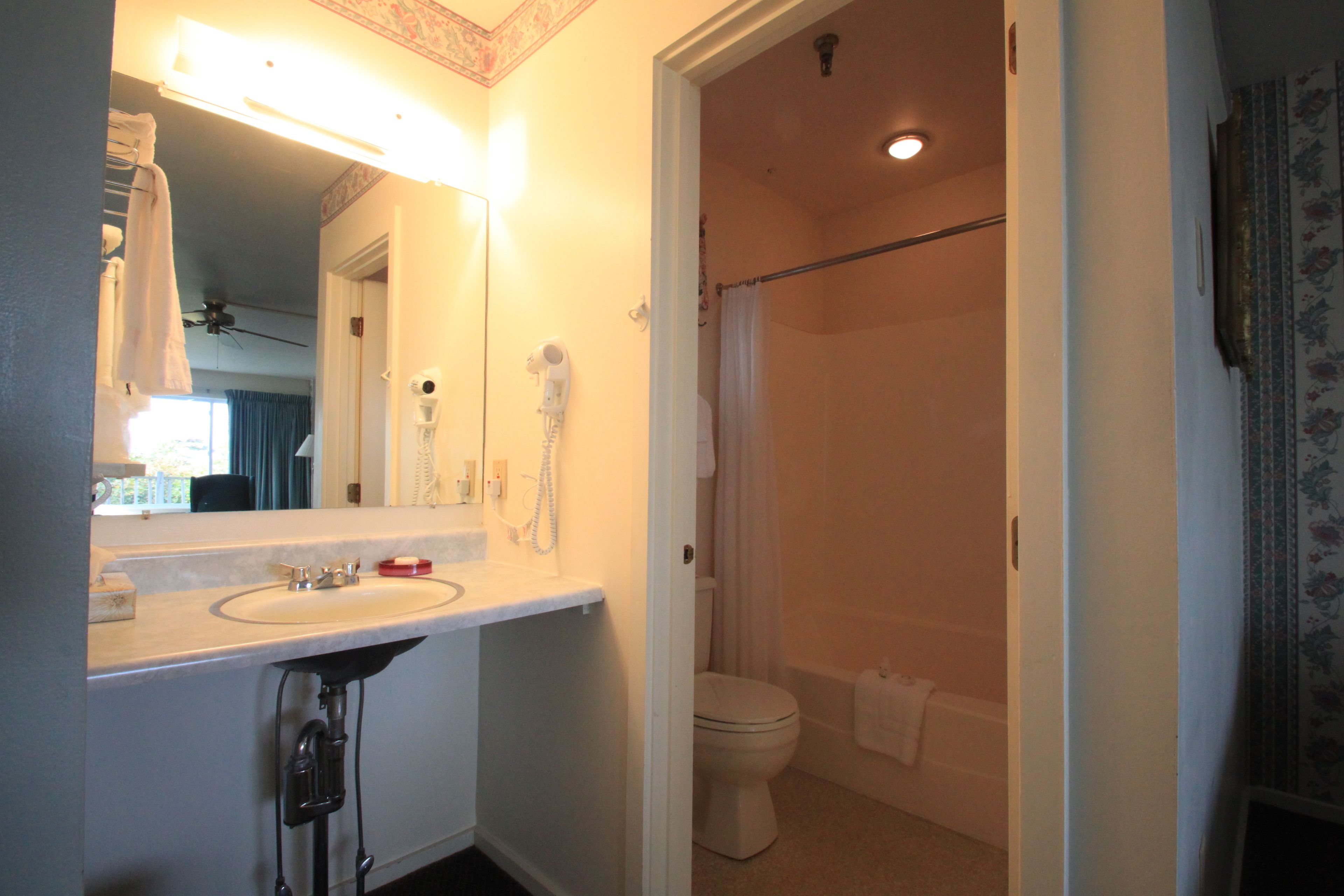 A bathroom with a sink, mirror, and toilet.