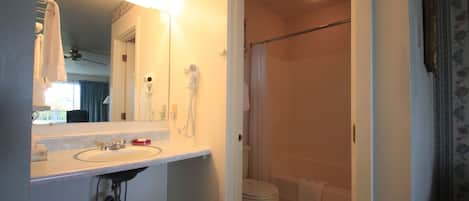 A bathroom with a sink, mirror, and toilet.