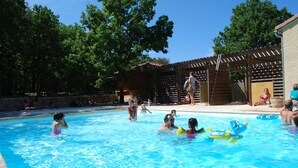Una piscina con gente y juguetes inflables.