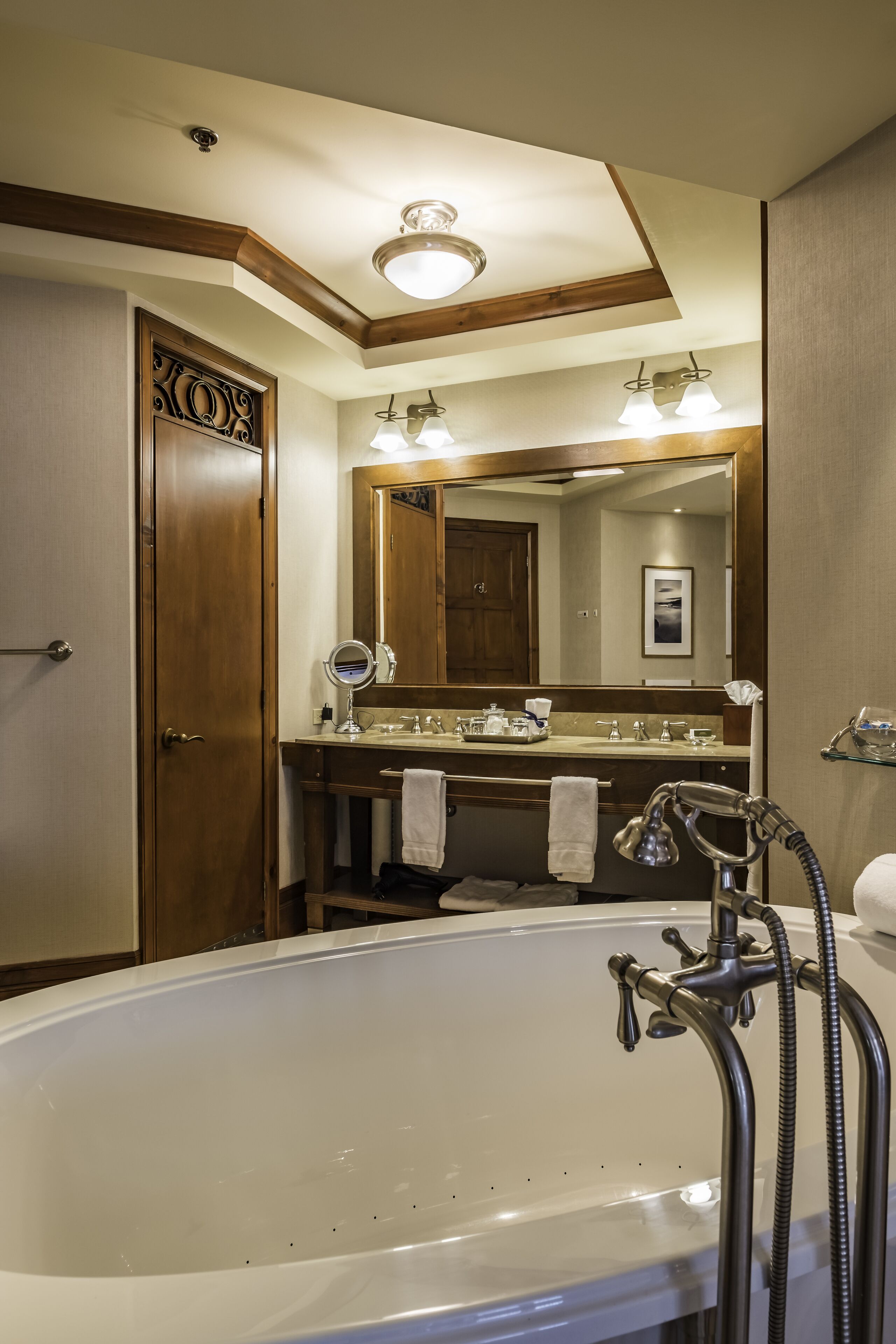 Une salle de bain avec une grande baignoire, un meuble-lavabo avec un miroir et une douche.