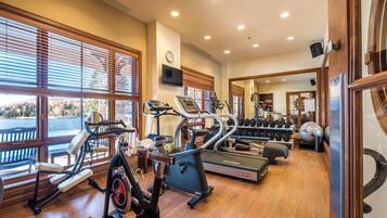 A gym with treadmills, elliptical machines, and free weights.