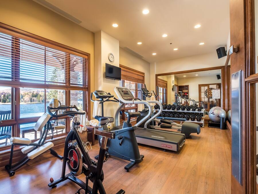A gym with treadmills, elliptical machines, and free weights.