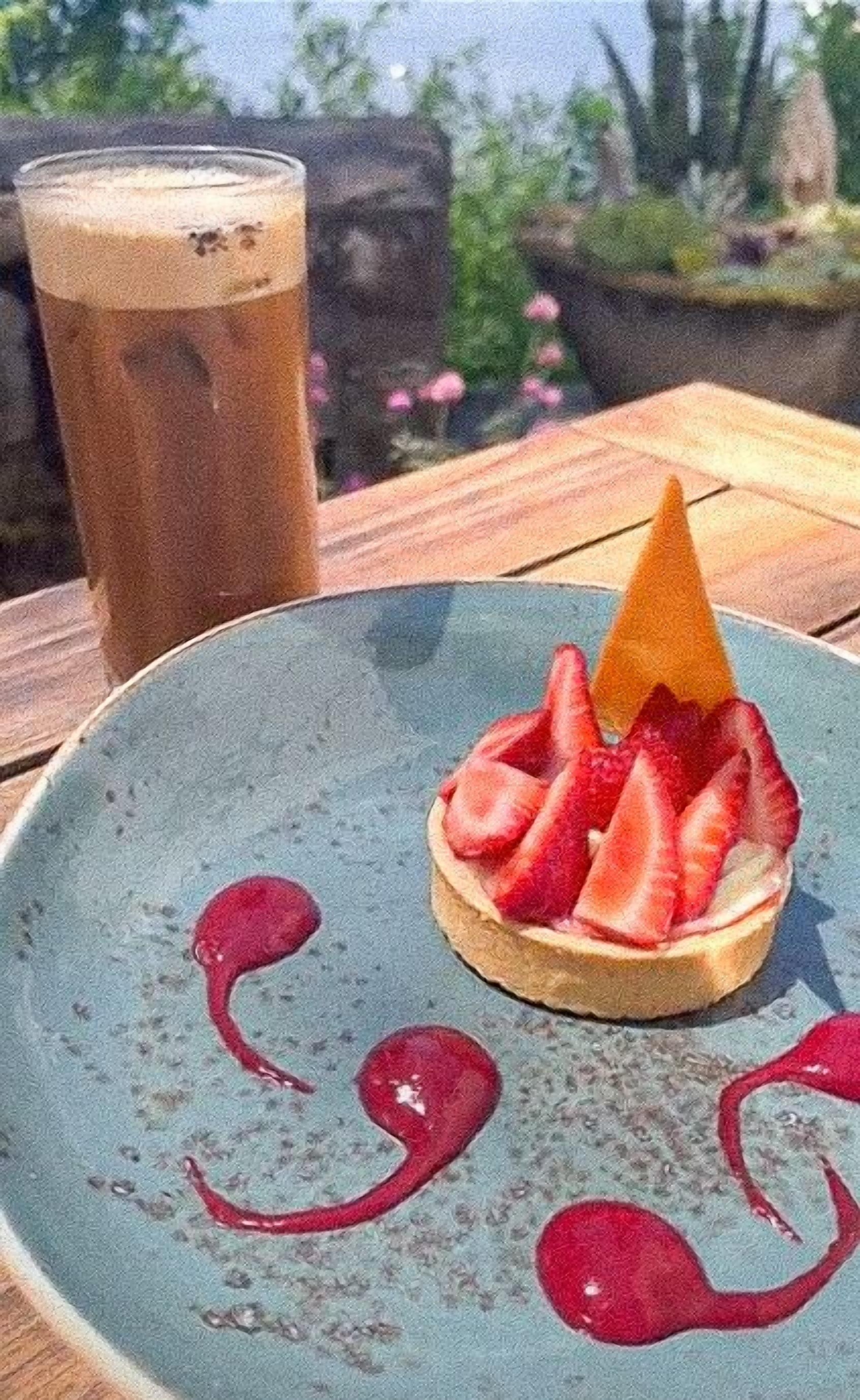 A dessert on a plate with a drink in the background.