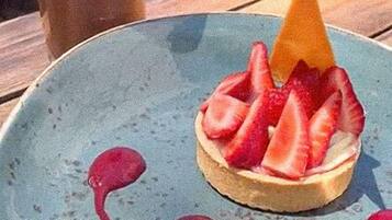 A dessert on a plate with a drink in the background.