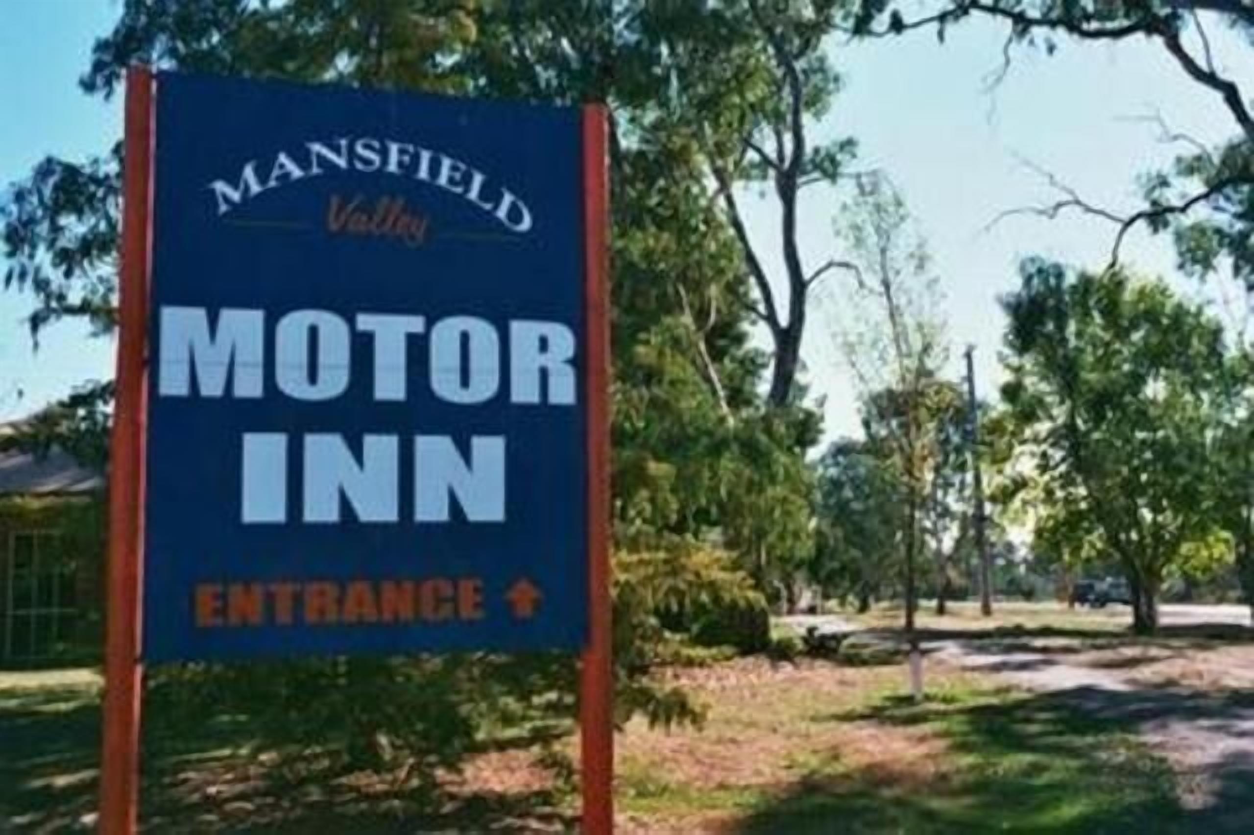 Señal del Mansfield Valley Motor Inn con flecha indicando la entrada.