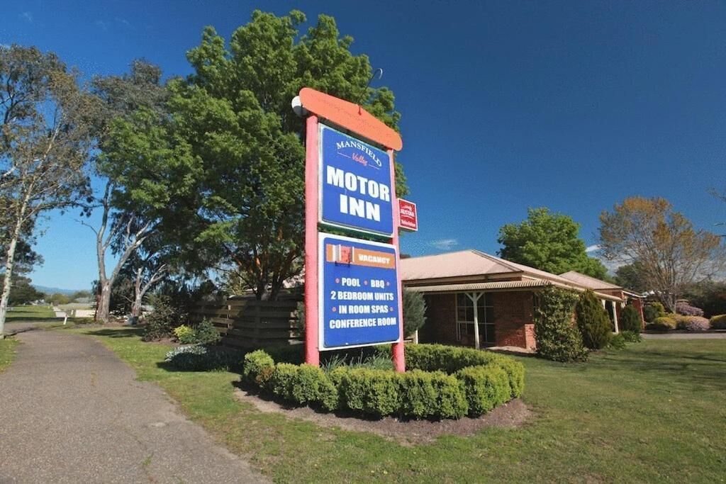 A sign for Mansfield Motor Inn advertising a pool, BBQ, 2 bedroom units, in-room spas, and a conference room.
