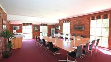A conference room with a long table, chairs, and a small counter.