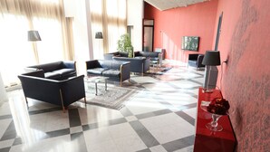 Uma sala de estar moderna com piso xadrez, uma parede de destaque vermelha e móveis contemporâneos.
