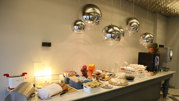 Um balcão de buffet com diversos alimentos e uma máquina de café.