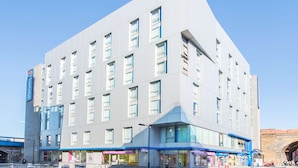 A modern hotel with a flat facade, multiple windows, and a corner entrance. - Travelodge London Central Southwark (London)