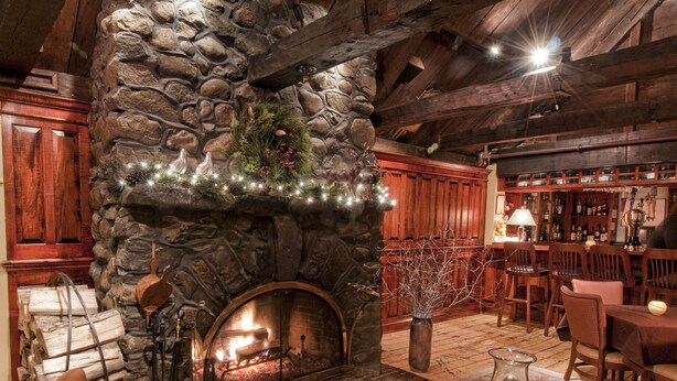 A cozy interior with a stone fireplace, leather seating, and a bar area. - York Harbor Inn (York Harbor)