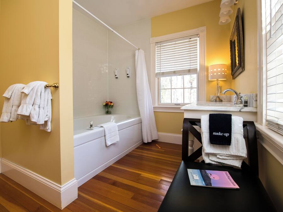 A bathroom with a bathtub, a sink, and a vanity table.