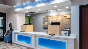 A reception desk with a modern design, featuring a blue illuminated panel and a digital display. - Holiday Inn Express & Suites Roanoke Rapids SE by IHG (Roanoke Rapids)
