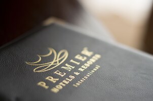 A black leather-bound book with gold embossed text reading "PREMIER HOTELS & RESORTS INTERNATIONAL".