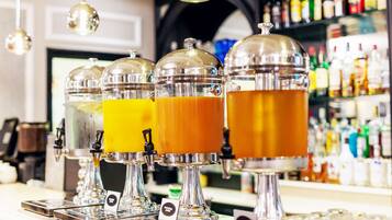 Un espace bar doté de plusieurs distributeurs de boissons, d’une sélection de bouteilles disposées en arrière-plan et d’un comptoir.