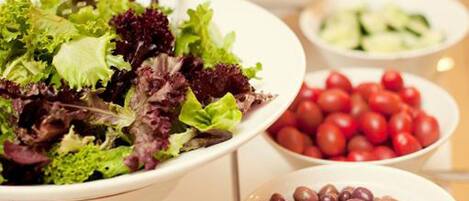 A buffet with various salads and vegetables.