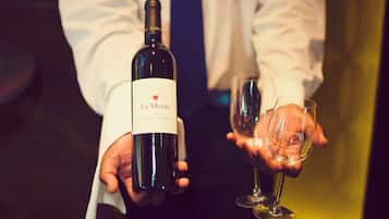 Una persona sosteniendo una botella de La Motte 2010 Cabernet Sauvignon y una copa de vino.