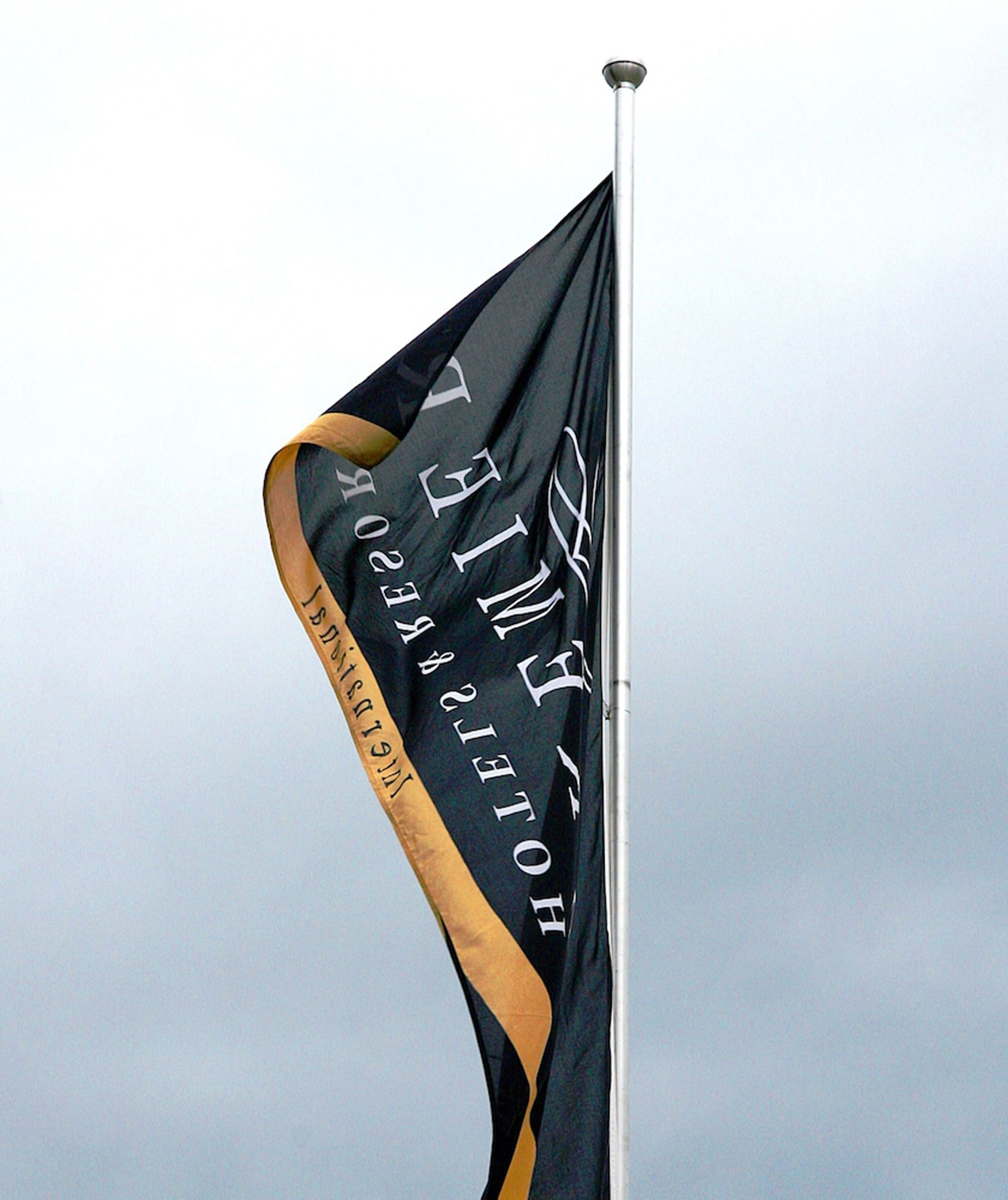 A flag with the text "HOTEL" and "HOTEL GROUP" on a flagpole.