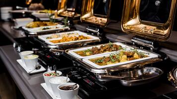 A buffet setup with multiple serving stations, each with a variety of dishes and condiments.