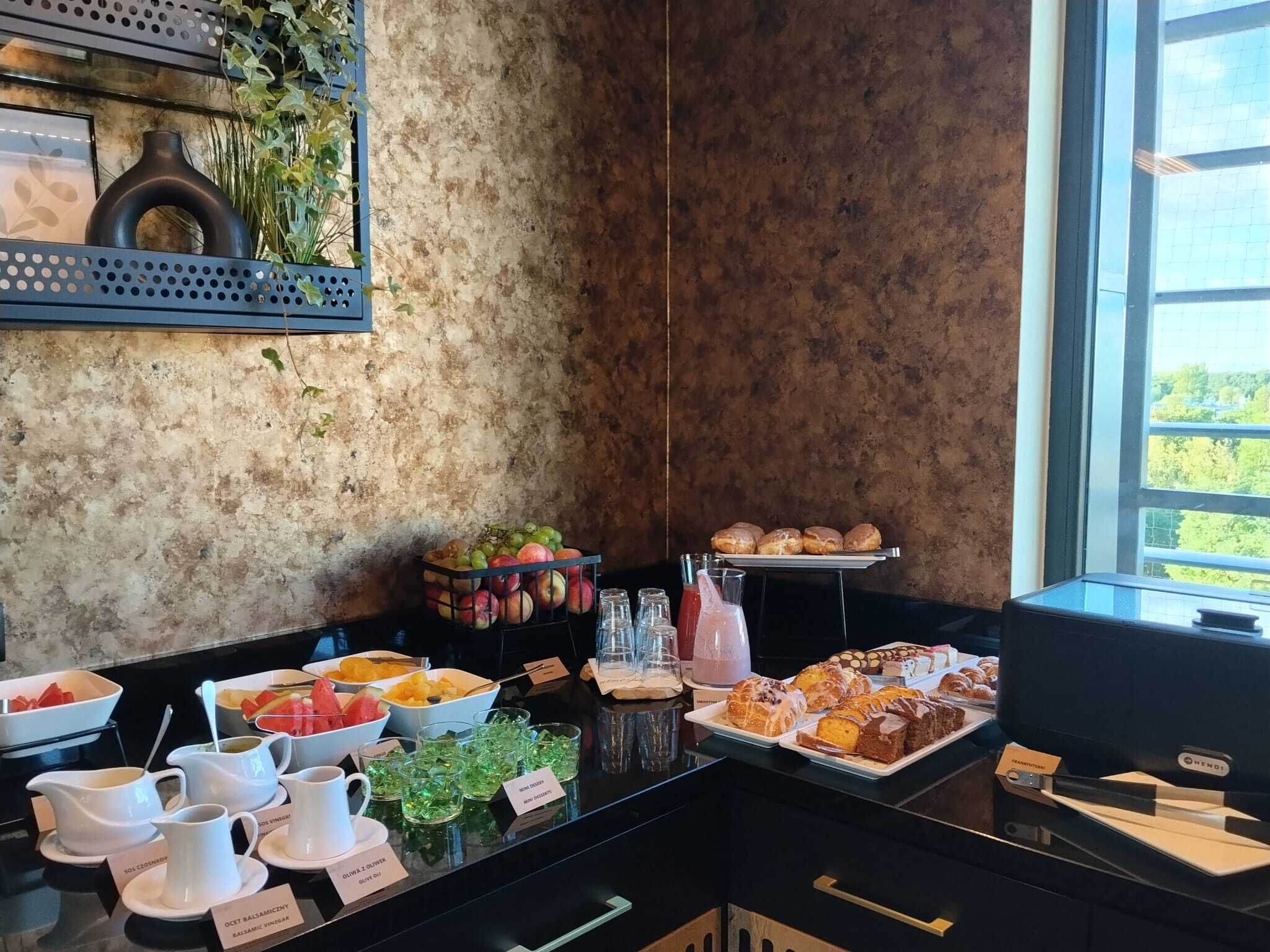 Un buffet de petit-déjeuner proposant une variété d’aliments, un coin café et une vue sur la verdure environnante.