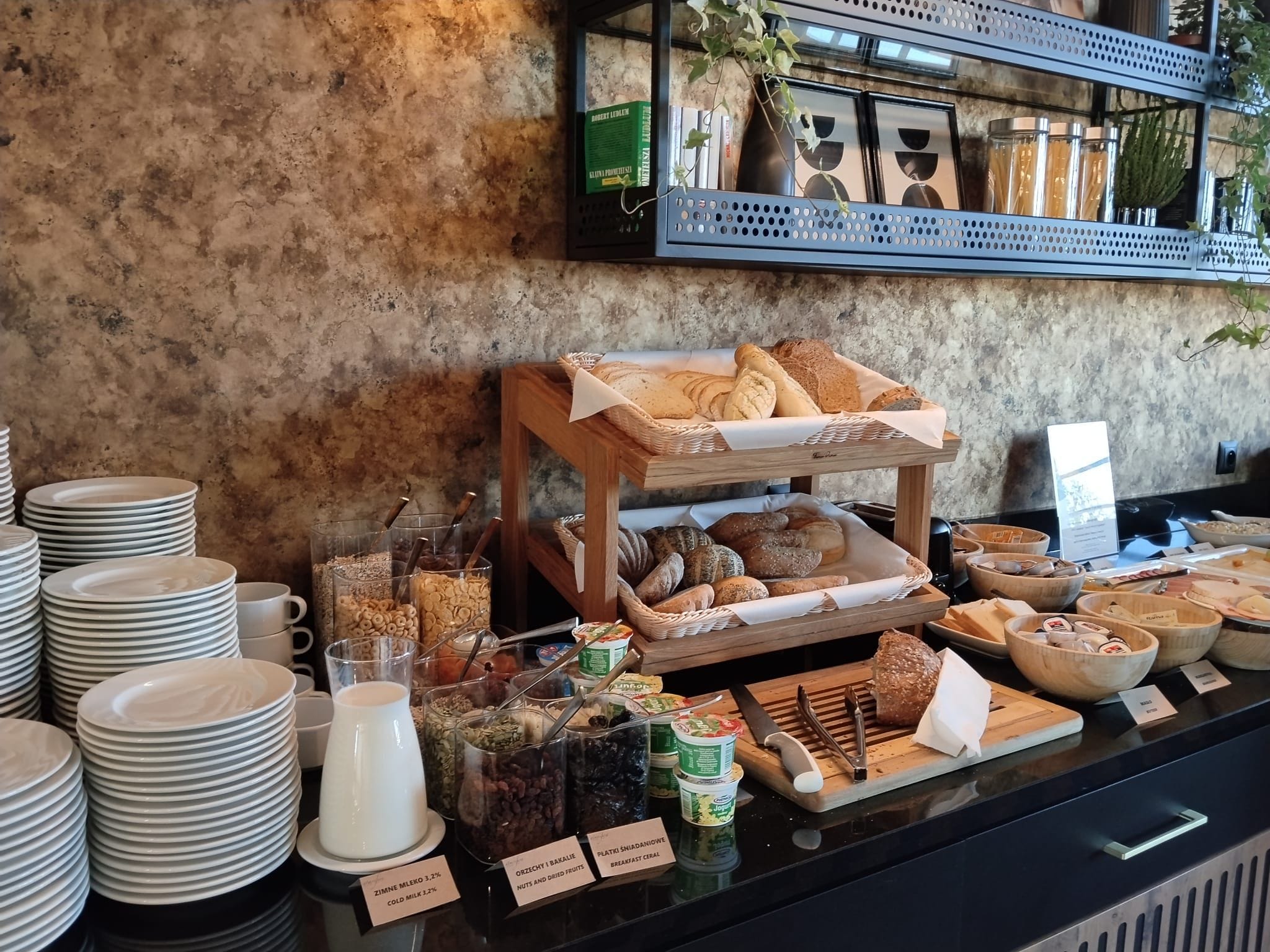 A breakfast buffet with various food items and a selection of books on a shelf.