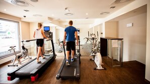 A gym with treadmills, stationary bikes, and exercise equipment.
