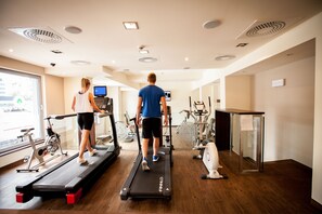 Un gimnasio con cintas de correr, bicicletas estáticas y equipo de ejercicio.