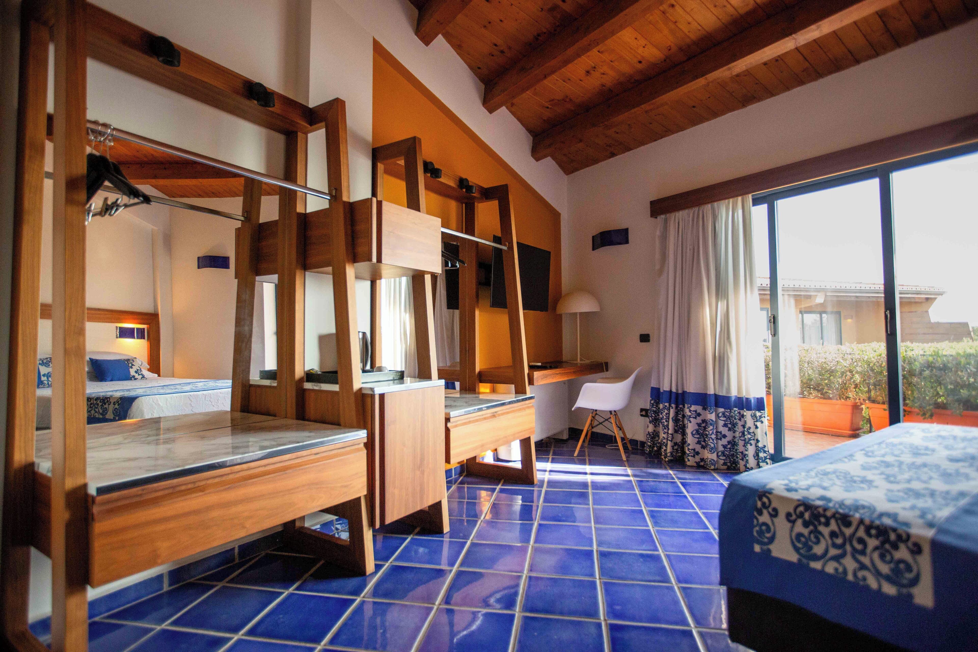 Un dormitorio con una cama de madera, un escritorio y una silla.