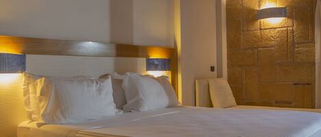 A neatly made bed with a wooden headboard and two bedside lamps.