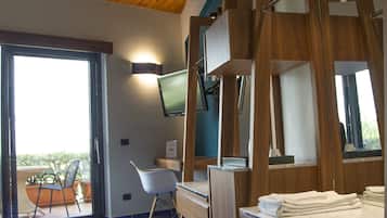Un baño moderno con un tocador de madera, un espejo grande y un televisor montado en la pared.