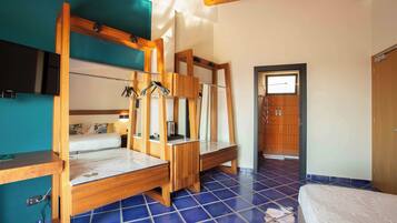 Una habitación con literas, un escritorio de madera y piso de baldosas.