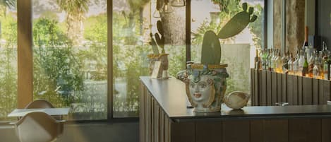 Un bar moderno con un ventanal grande, paneles de madera y una decoración con cactus.