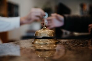 A brass bell on a reflective surface, likely a reception area. - Sonnenhotel Hoher Hahn (Schwarzenberg/Erzgeb.)