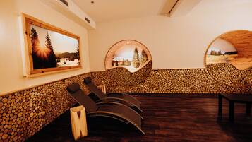 A spa room with wooden flooring, a wall-mounted massage table, and a large window with a scenic view.