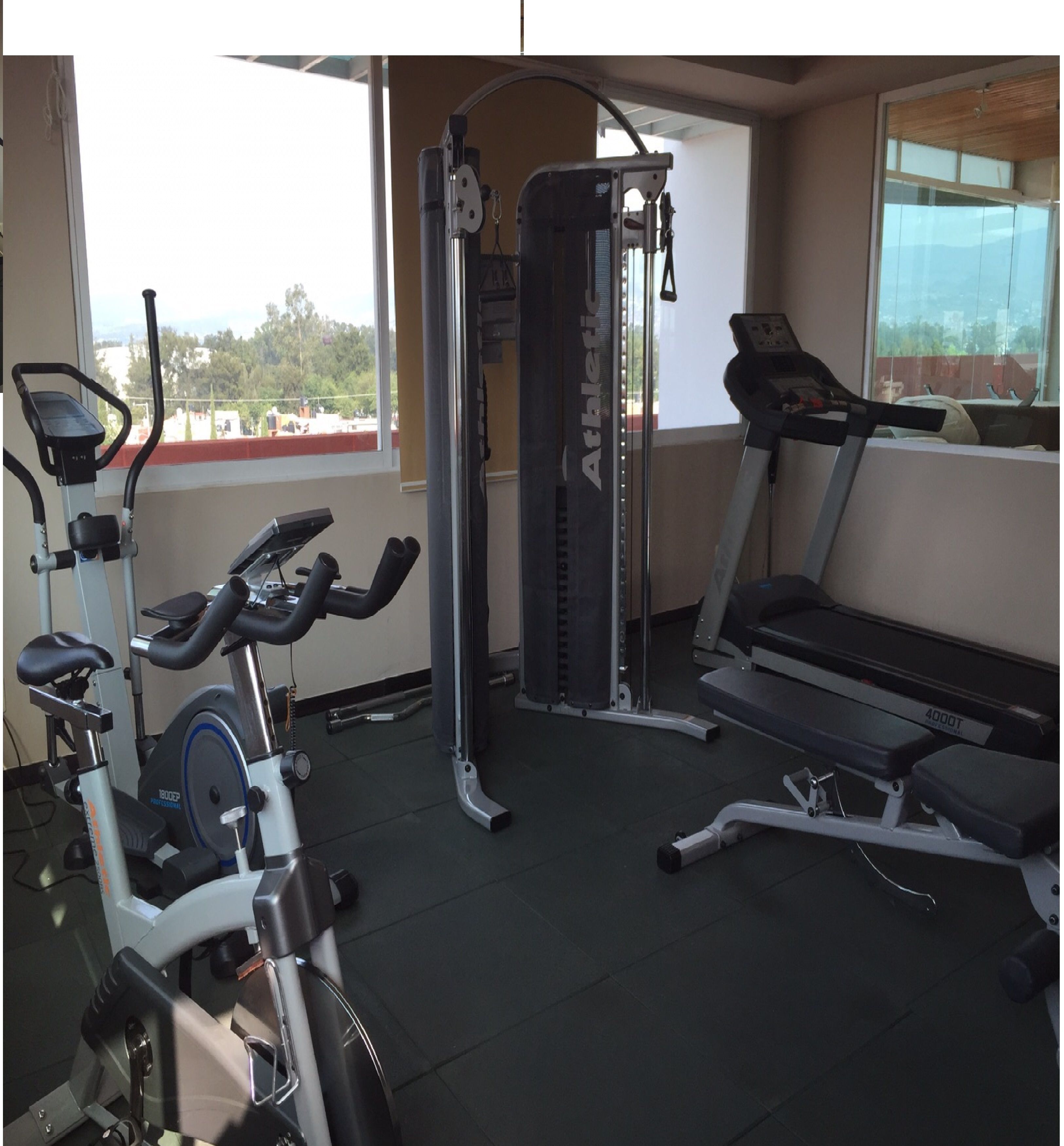 A gym with cardio equipment, weight machines, and a treadmill.