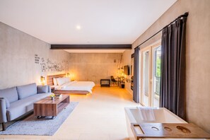 A modern hotel room with a bed, sofa, and a dining area. - Stark Boutique Hotel and Spa Bali (Kuta)