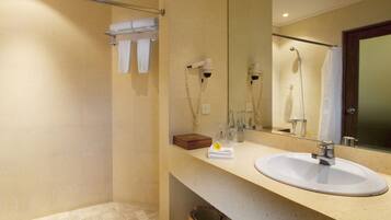 A bathroom with a sink, mirror, towel rack, and shower area.