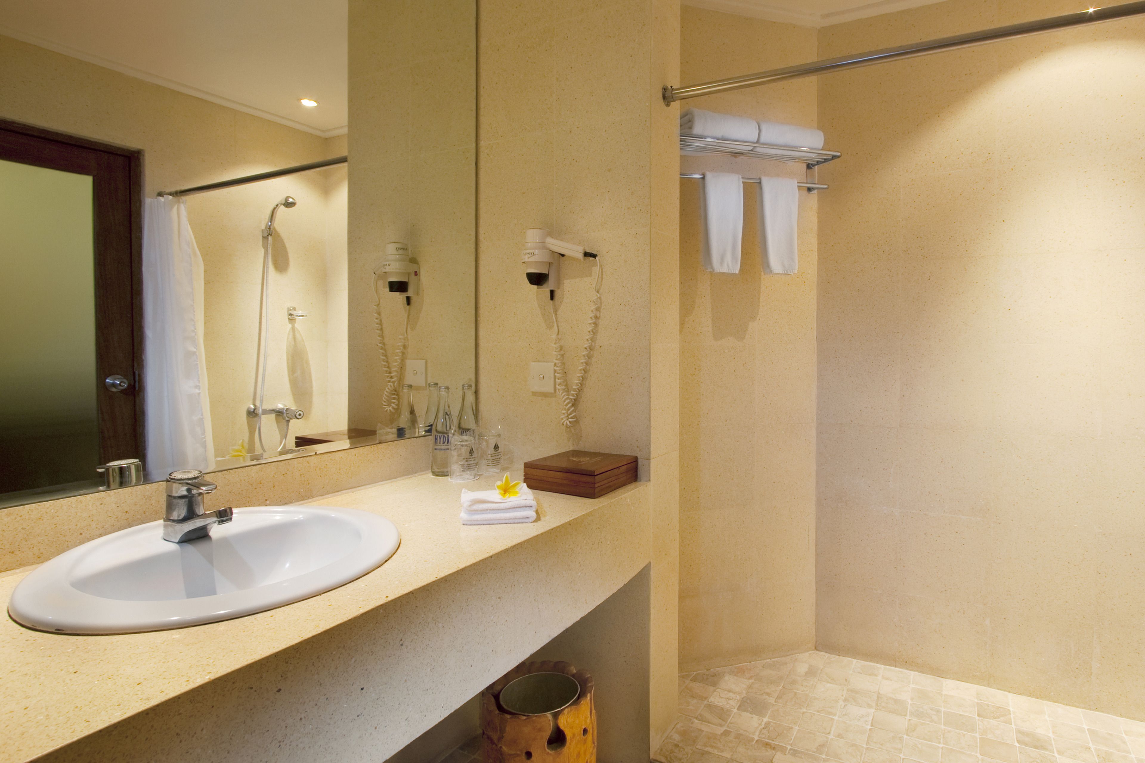 A bathroom with a sink, mirror, and shower.