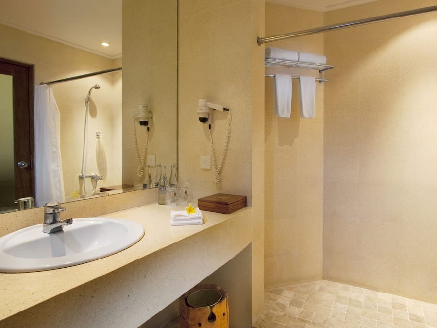Un baño con lavamanos, espejo y ducha.