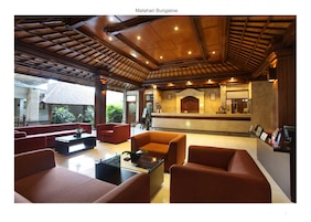 Un área de recepción con techo de madera, sofás rojos y mostrador de recepción.