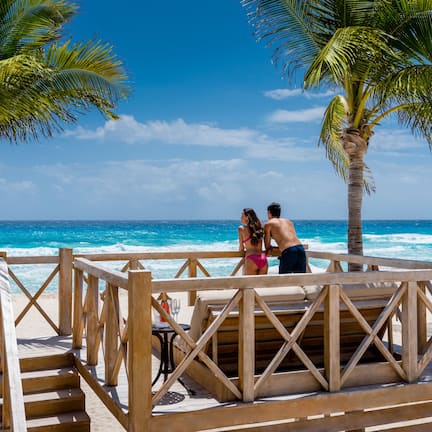 On the beach, white sand, beach cabanas, sun loungers