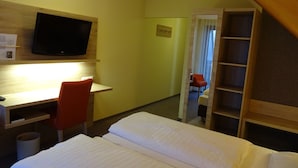 A hotel room with a bed, a desk, a chair, a television, and a wardrobe. - Gasthof Hotel Zum Ross (Wertheim)
