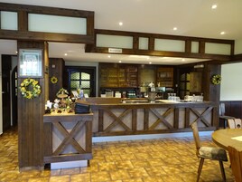 Zona de recepción con un mostrador de madera, un letrero de recepción y un mostrador con diversos artículos.