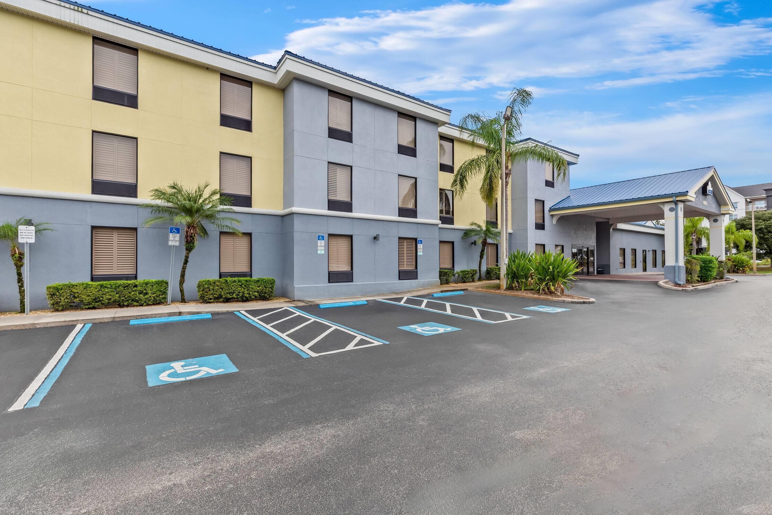 Un parking doté de places réservées aux personnes handicapées et un bâtiment à l’architecture moderne.