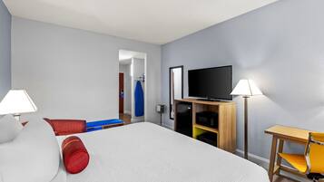 Une chambre d’hôtel avec un lit, une télévision, un bureau et une chaise.