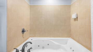 Un bagno moderno con una vasca da bagno indipendente, un soffione doccia e un portasciugamani.