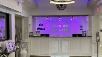 Una recepción con un cartel iluminado en morado que dice "DAYS INN & SUITES".