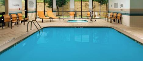 An indoor swimming pool with lounge chairs and a no diving sign.